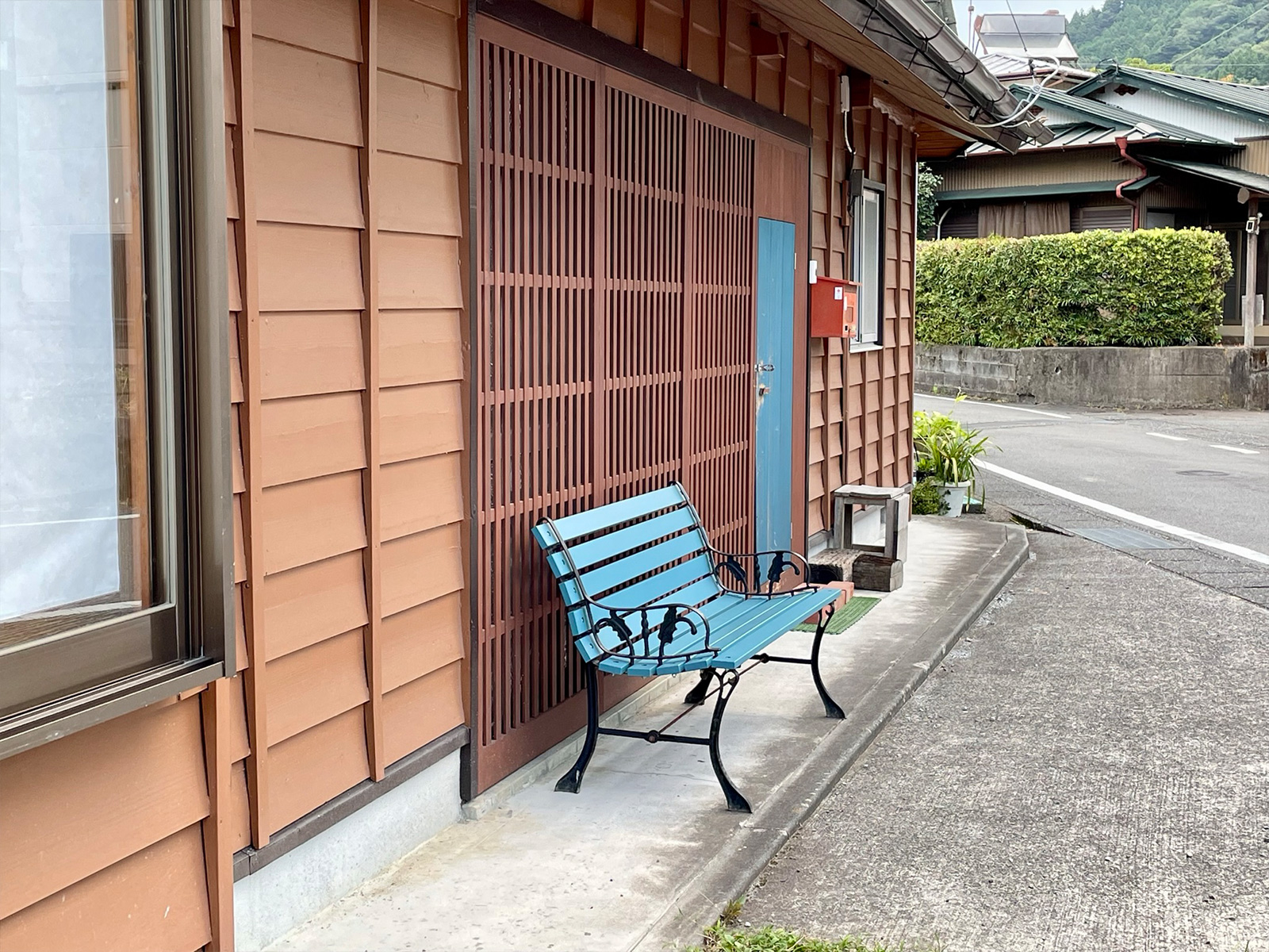 青色のくぐり戸とベンチを設けた玄関まわり